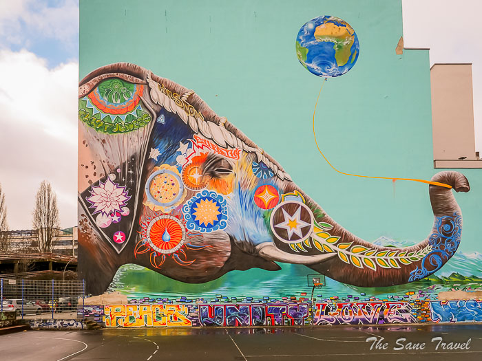 A colorful and large-scale mural on a building in Berlin's Kreuzberg district, showcasing intricate details and bold imagery.