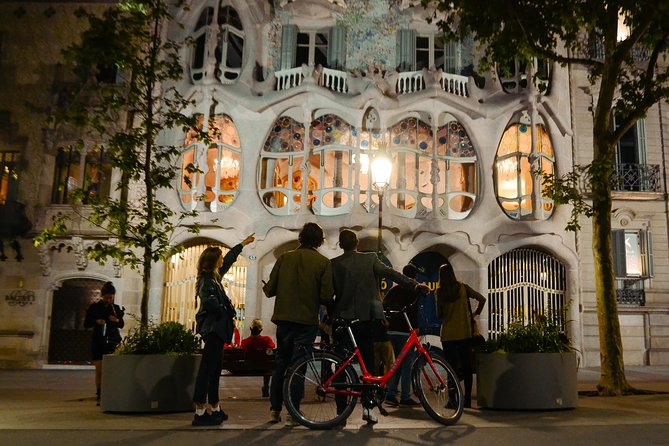 Cyclists riding bikes on a nighttime tour of Barcelona