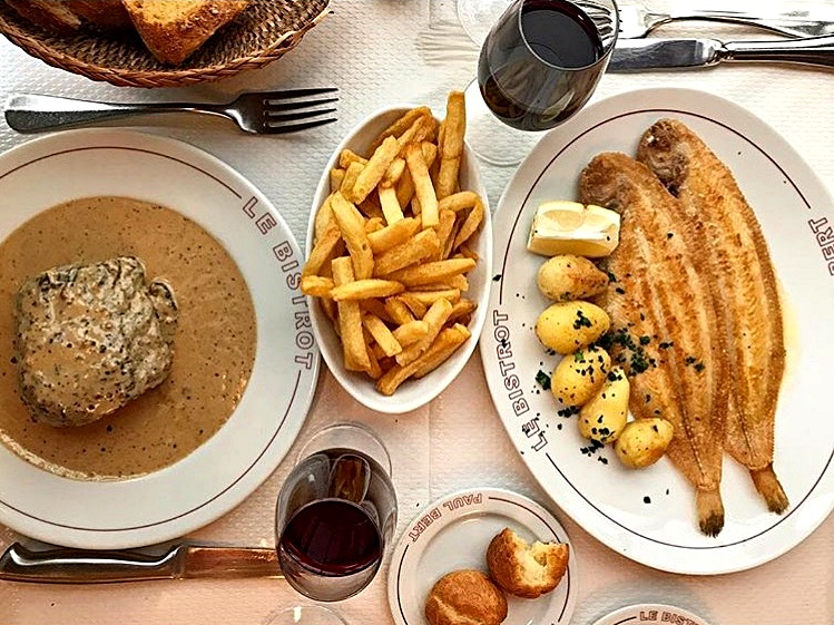 A table of traditional French cuisine at a Parisian bistro.