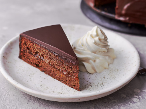 A slice of Sachertorte served with whipped cream