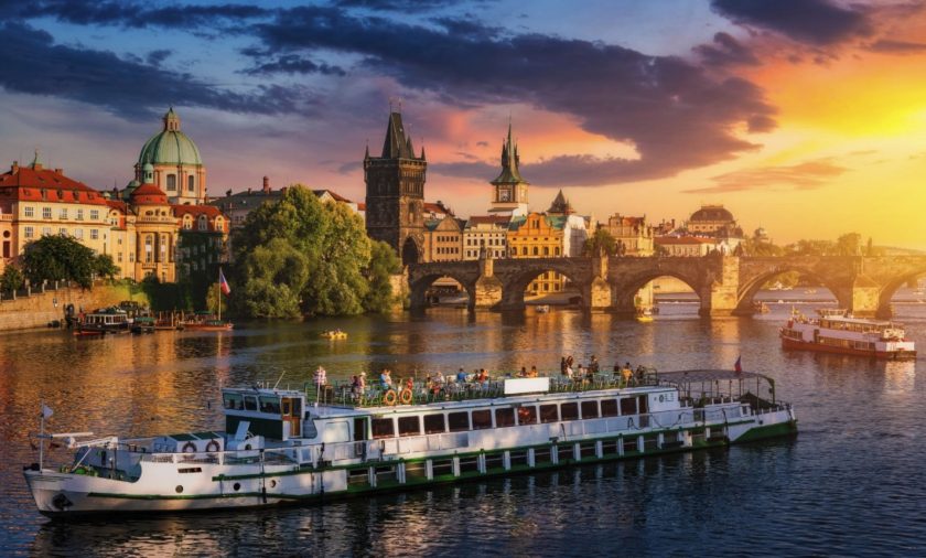 Prague river cruise sailing at sunset with city skyline in the background