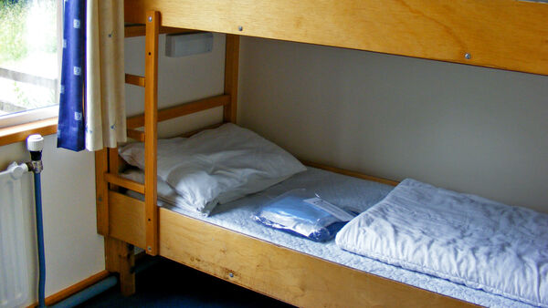 A tidy dormitory room with bunk beds in a bustling European hostel, showcasing budget accommodation.