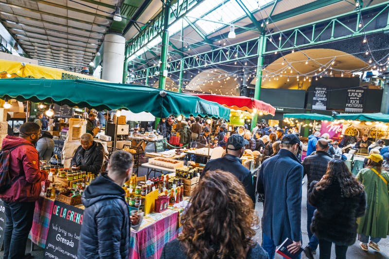A vibrant scene at Borough Market in London, showcasing numerous food stalls and shoppers.