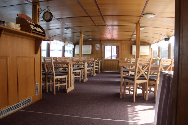Interior of a Prague dinner cruise boat with tables set for dining