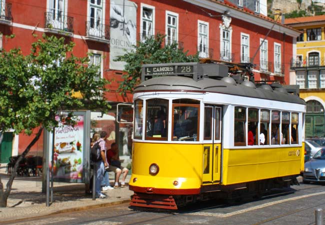 Yellow Tram 28 traveling through the Alfama district in Lisbon