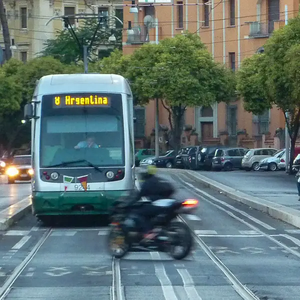 A tram moving along cobblestone streets in the historic center of Rome