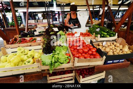 A bustling Parisian market stall filled with colorful fresh fruits, vegetables, and artisanal cheeses.
