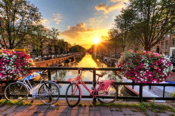 Cyclists riding along a canal in Amsterdam